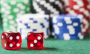dice showing 7 in front of poker chips