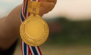 hand holding gold medal