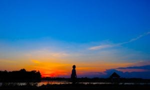 silhouette of woman walking at sunset