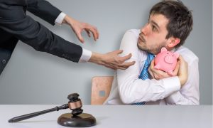 man clutching piggy bank in courtroom