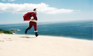 Santa Claus running on a sunny beach