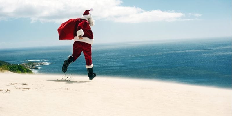 Santa Claus running on a sunny beach