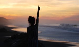 woman in silhouette with arm in air