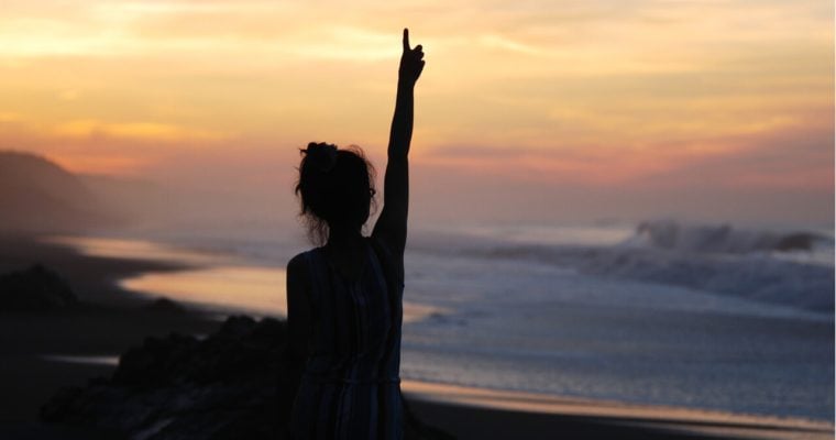 woman in silhouette with arm in air