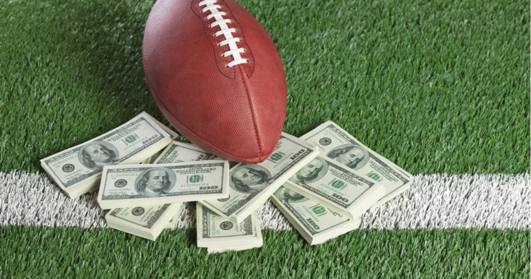 Football on a field with some dollar notes
