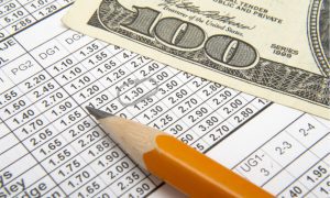 An image of a 100 dollar note on a piece of paper containing sports betting odds.