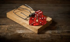 Three red dices on a mouse trap