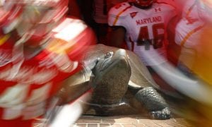 Maryland football team run onto the field past a Terrapin