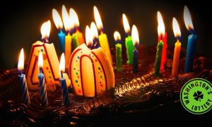 Birthday cake with lit candles and #40 with Washington's Lottery logo