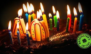 Birthday cake with lit candles and #40 with Washington's Lottery logo