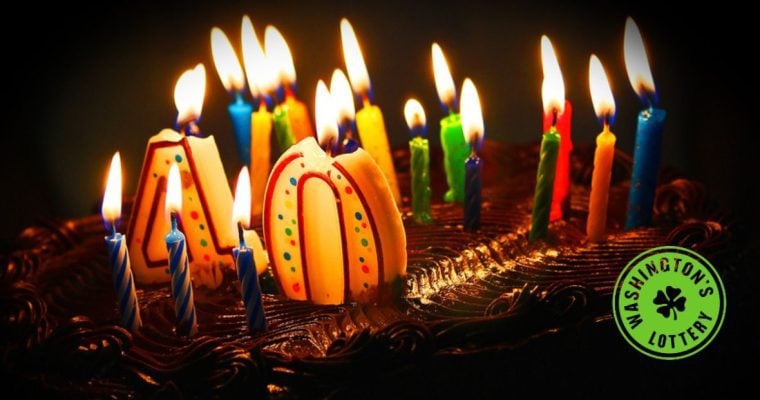Birthday cake with lit candles and #40 with Washington's Lottery logo