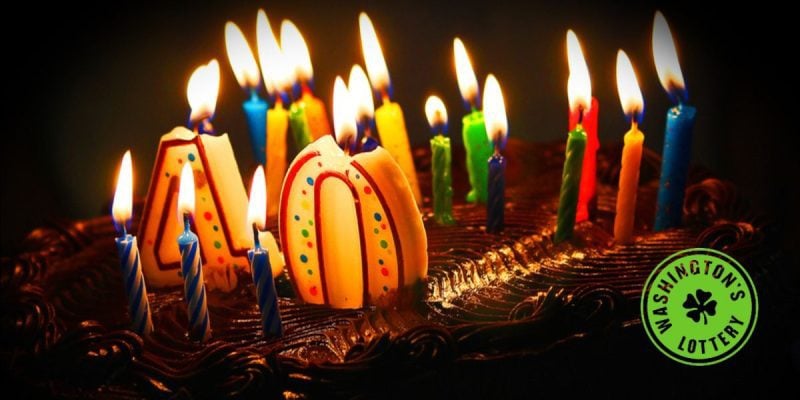 Birthday cake with lit candles and #40 with Washington's Lottery logo
