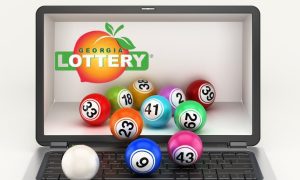 lottery balls protruding from computer with georgia lottery logo on screen
