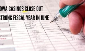 hand writing with pencil on financial ledger simulating the past fiscal year for iowa casinos
