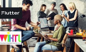 African-American Woman Brainstorming With Co-workers In Office with Flutter Entertainment and WiHTL logos