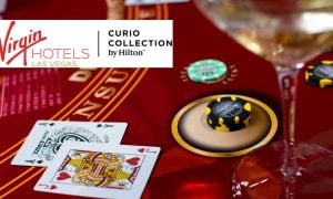 Red Gaming Table with Playing Cards and Money Chips with Virgin Hotels Las Vegas logo
