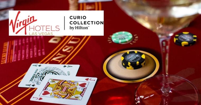 Red Gaming Table with Playing Cards and Money Chips with Virgin Hotels Las Vegas logo