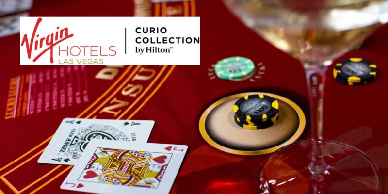 Red Gaming Table with Playing Cards and Money Chips with Virgin Hotels Las Vegas logo