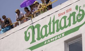 people standing above nathan's famous hot dog stand on coney island