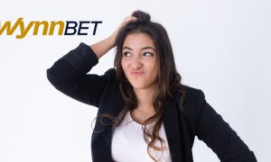 woman scratches head next to the wynnbet logo