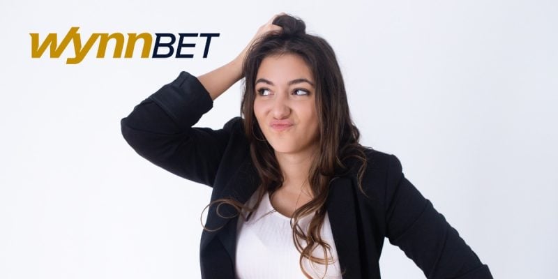 woman scratches head next to the wynnbet logo