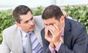 one man consoles another who appears stressed