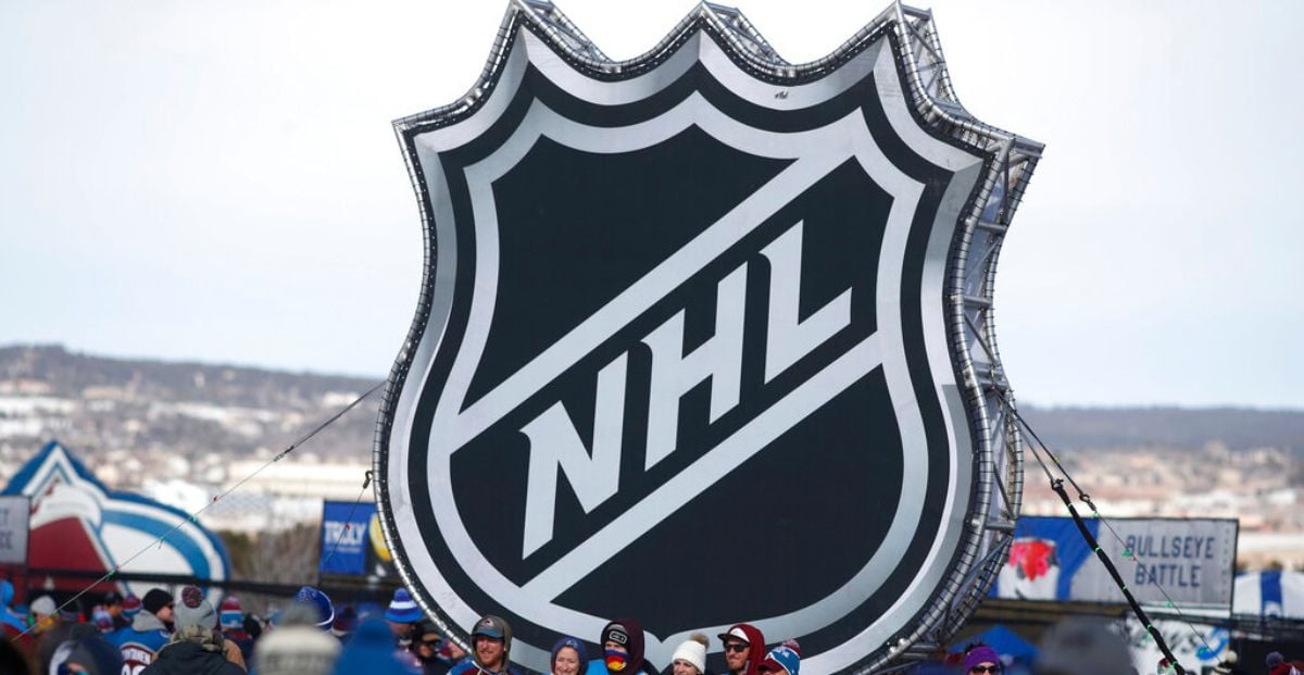 Fans Pose Below NHL League Logo