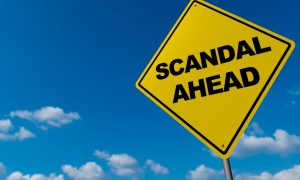 road sign reading scandal ahead