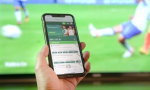 hand holding phone with sportsbook