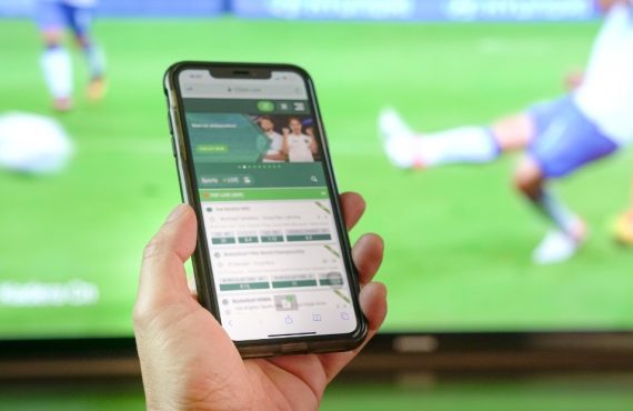 hand holding phone with sportsbook
