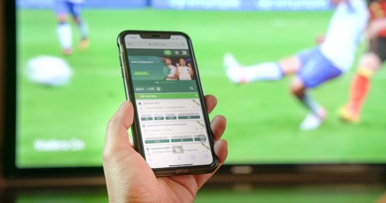 hand holding phone with sportsbook