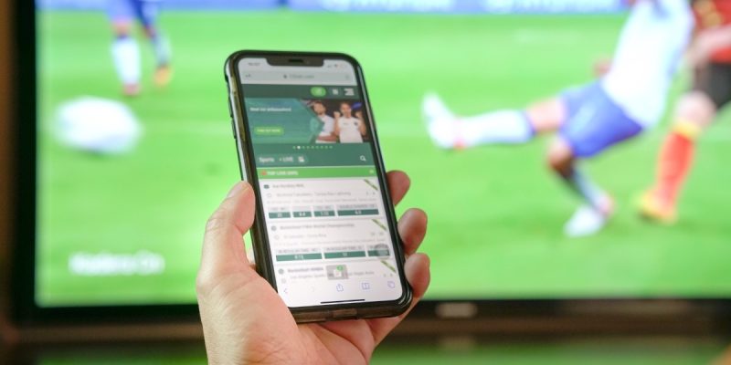 hand holding phone with sportsbook