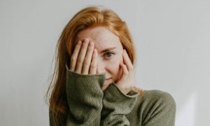 person covering eye with hand