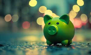City Lights Shine Behind Green Piggy Bank