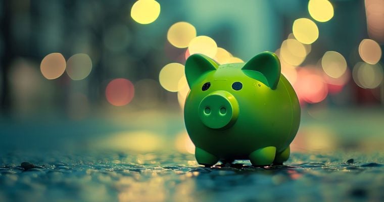 City Lights Shine Behind Green Piggy Bank