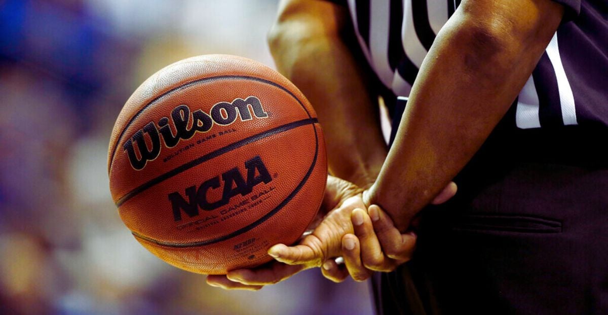 Official Holds NCAA Basketball At Game