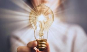 Woman Holds Shining Light Bulb