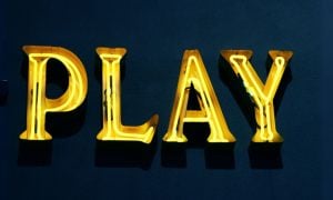 Yellow Neon Play Sign On Green Background