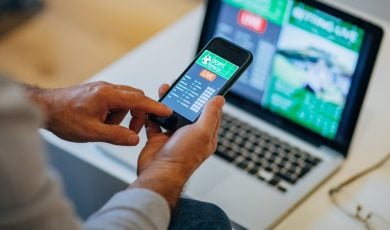 hand holding cell phone with sportsbook app