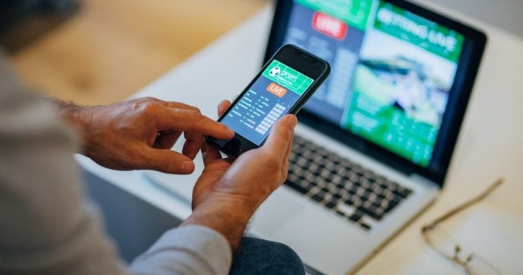 hand holding cell phone with sportsbook app