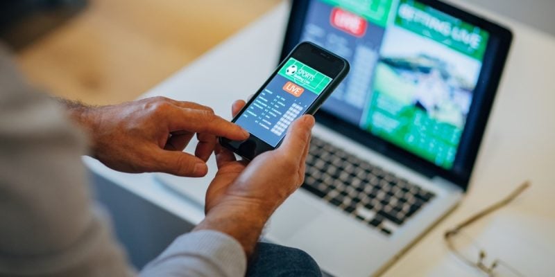hand holding cell phone with sportsbook app