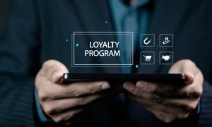 Man Holds Tablet With Loyalty Program Text Above