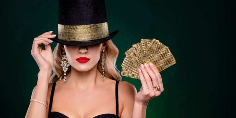 Sexy Woman With Top Hat Holding Gold Playing Cards