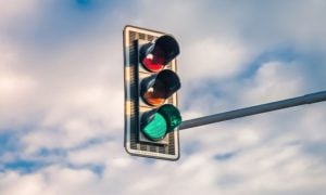 Green Traffic Light Lit Against Cloudy Sky