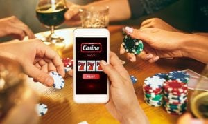 Man Holds Cell Phone Displaying Online Casino