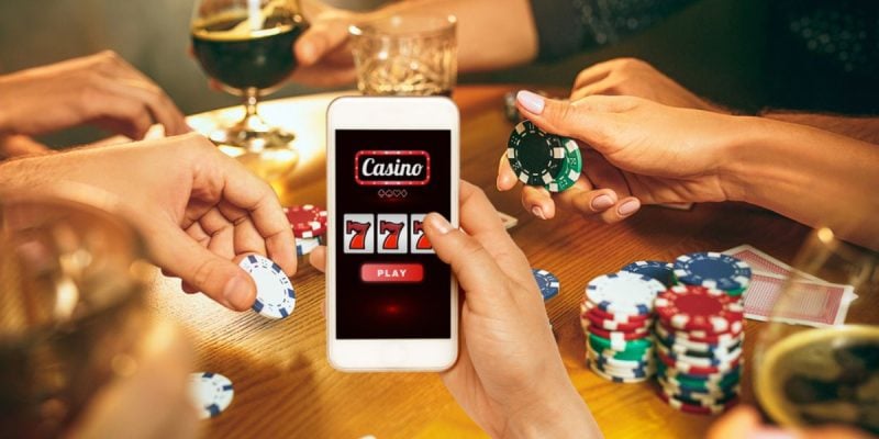 Man Holds Cell Phone Displaying Online Casino