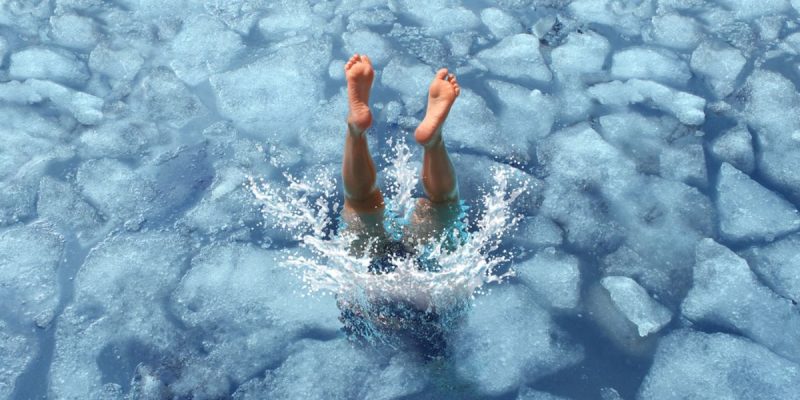 Man's Legs Break Surface Of Ice Water