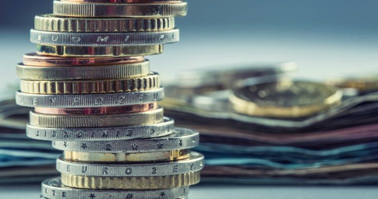Stacked Coins In Forefront Money Laying In Background