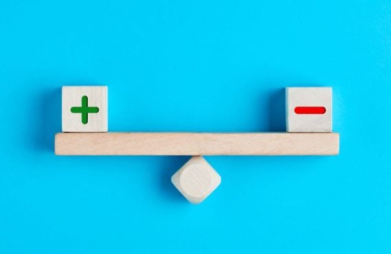 a balance on a blue background with a plus and a minus on each end