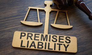 a golden scale symbol with premises liability written on it